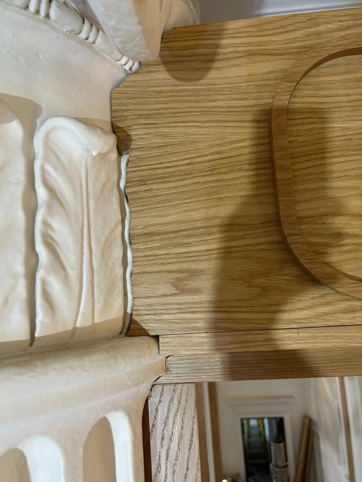 An oak header panel fitted round the same carved capital with no visible gap