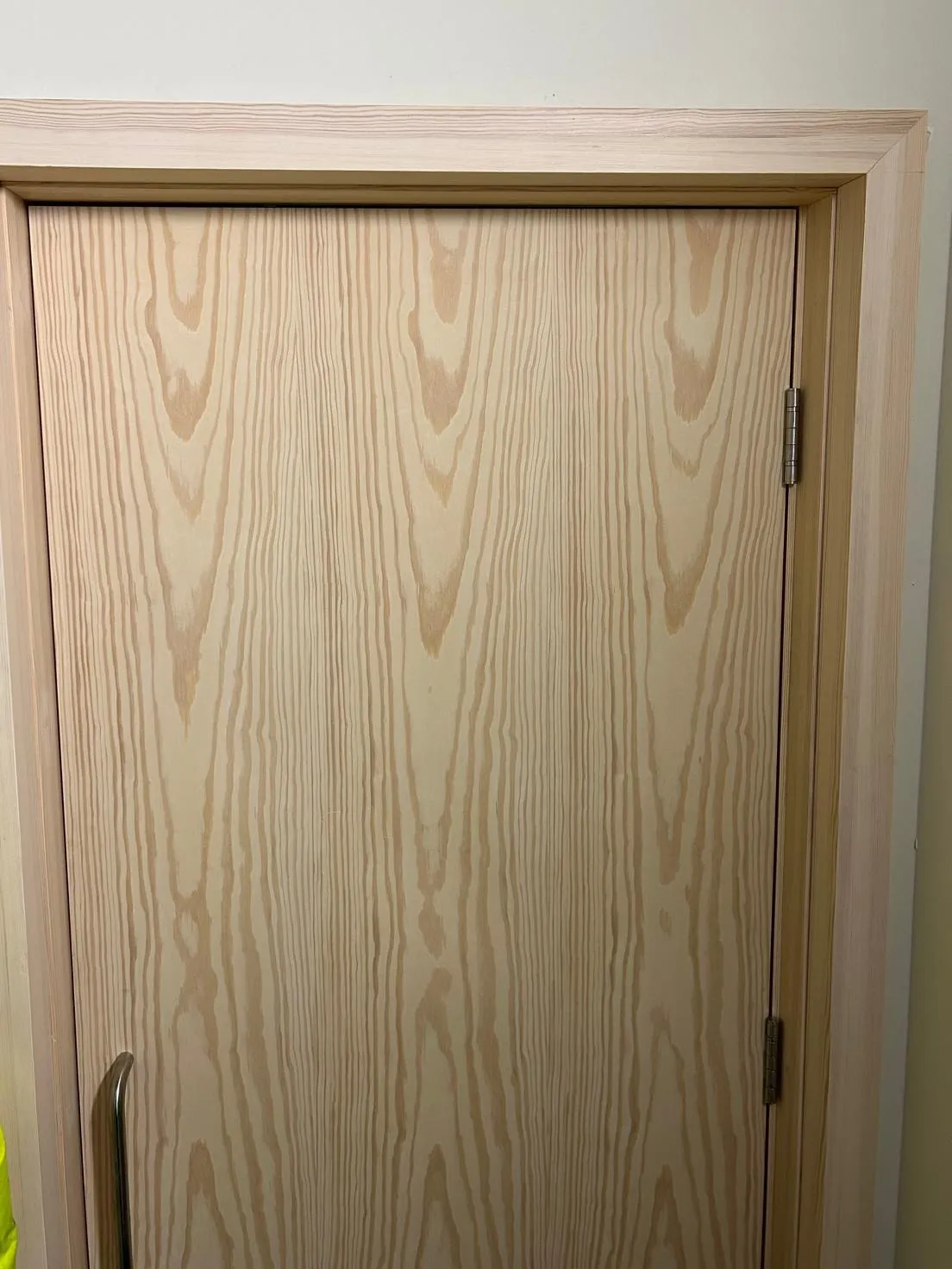 A pale wood door with a new lining and architrave